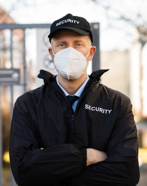 Security Officer In Covid Face Mask Outside Building